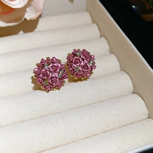 Detail of purple floral stud earrings with rhinestones in a beige velvet jewelry box