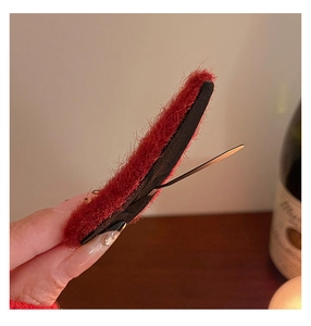 Dettaglio della clip per capelli in velluto rosso vintage con molletta in metallo