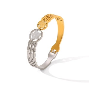 Detail of two-tone stainless steel bangle featuring frosted star motifs and wavy cutout