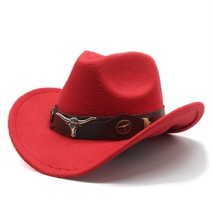 Détail d'un chapeau de cowboy en feutre rouge avec bande en cuir et tête de taureau