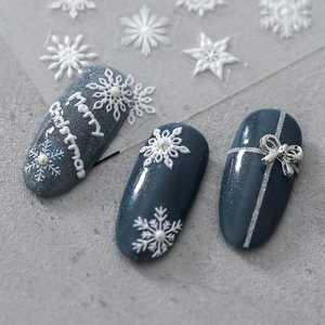 3D embossed Christmas nail stickers featuring white snowflakes and silver bow designs