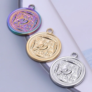 Macro detail of owl coin pendants in iridescent, gold, and silver stainless steel finishes