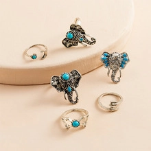 Detailed view of vintage silver elephant rings set with turquoise stones on a round surface