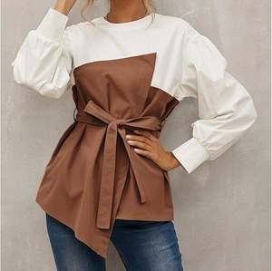Detail of elegant color-block shirt with lantern sleeves and adjustable waist tie