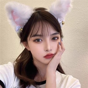 Détail d'un serre-tête oreilles de chat en peluche blanche avec doublure rose et clochettes
