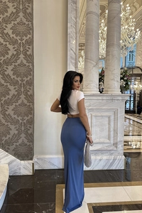 Slim fit high waist blue maxi skirt with white crop top in luxury hotel setting