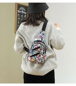 Detail shot of women's nylon crossbody chest bag featuring a colorful abstract pattern
