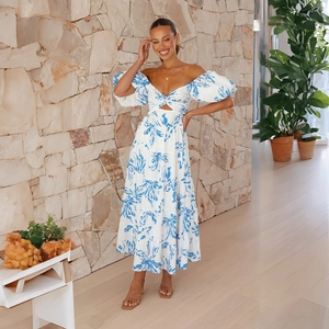 Detail of off-shoulder floral dress with puff sleeves and blue leaf print pattern