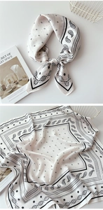 Detail of black and white paisley silk scarf used as a stylish headband and neck tie
