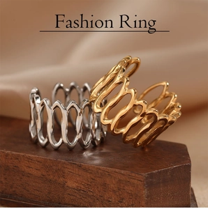 Close-up of gold and silver minimalist wavy hollowed-out rings on wooden display