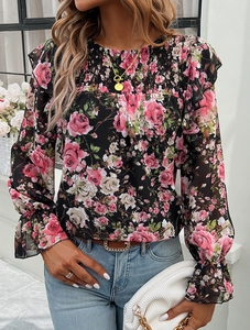 Detail of floral chiffon shirt sleeve with delicate ruffles and colorful flower patterns