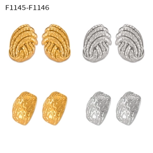 Détail de boucles d'oreilles dorées et argentées aux textures géométriques variées