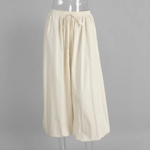 Close-up of elastic drawstring waistband on beige cotton loose-fit lantern pants