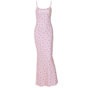Détail d'une robe longue rose à fleurs avec fines bretelles et motifs de cerises