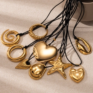 Collection of gold pendant necklaces with black cords in heart and starfish shapes