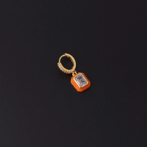 Detail of gold zircon earrings with orange enamel frame and rectangle crystal on black background