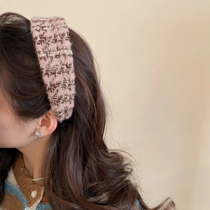 Detailed close-up showing the pink and brown woven tweed texture of the padded headband