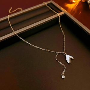 Détail du collier en or avec pendentif papillon en nacre et perle dans un écrin luxe