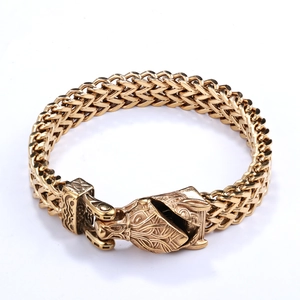 Macro shot of Viking wolf head relief on antique gold braided stainless steel bracelet