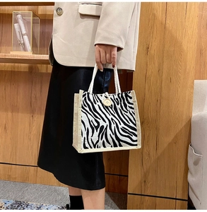 Detail of zebra print canvas tote with woven handle and round wooden button closure