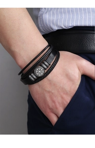 Close-up of men's multi-layer black braided leather bracelet with Viking compass charm