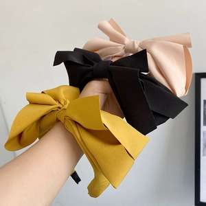 Close-up of pink, black and yellow fabric bow headbands with wide retro design