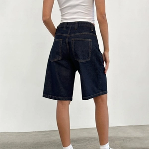 Rear view of dark blue denim bermuda shorts showing back pockets and orange stitching