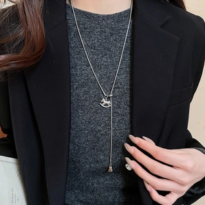 Silver horse pendant sweater necklace styled on a model with a black blazer