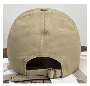 Vue détaillée d'une casquette en coton kaki avec boucle en métal et œillets d'aération