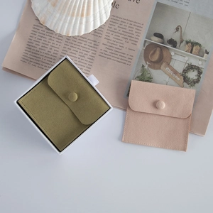 Detail of pink and olive green velvet jewelry pouches with snap button closure