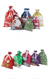 Close-up of assorted Christmas drawstring gift bags with festive prints and ribbons