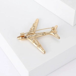 Macro view of the golden metal airplane brooch back with a secure pin fastening mechanism