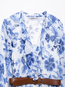 Detail view of floral chiffon dress featuring ruffle V-neckline and brown leather belt