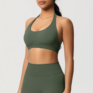 Détail d'une brassière de sport licou vert foncé et d'un legging à texture côtelée