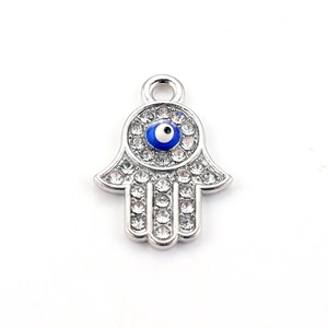 Macro shot of silver Hamsa Hand pendant with blue evil eye enamel and rhinestones