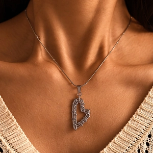 Silver bead chain necklace featuring a unique woven heart pendant on a model