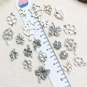 Assorted silver alloy four-leaf clover charms for DIY jewelry making with ruler scale