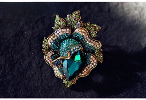 Macro view of vintage flower brooch with green gemstone and colorful rhinestones