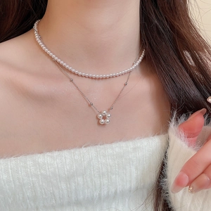 French vintage double-layer necklace featuring pearl strands and floral pendant on model