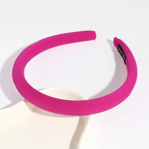 Macro shot of rose red sponge padded headband with handmade label on inner band