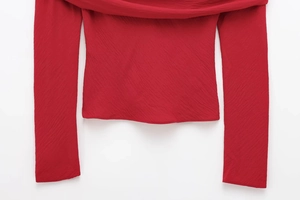 Detailed macro view of the ruched red chiffon fabric and elastic neckline of the top
