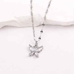 Détail d'un pendentif papillon argenté avec zircon sur une chaîne à maillons plats