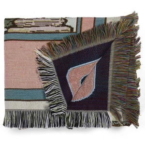 Detail of woven bohemian camping blanket featuring colorful fringe and jacquard texture