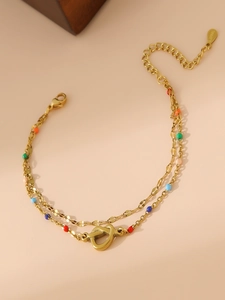 Detail of 18K gold stainless steel double-layer bracelet with colorful beads and heart charm