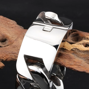 Polished men's heavy titanium steel Cuban link bracelet on dark wood background