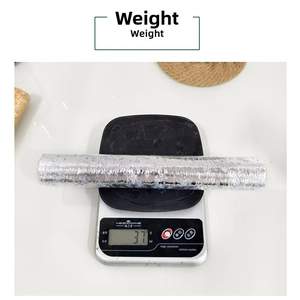 Detailed weight measurement of a silver foil mesh table runner roll on a digital scale
