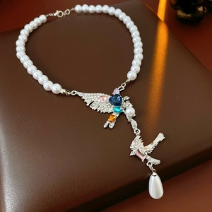 Détail du collier pendentif oiseau avec cristaux colorés et perle poire pendante