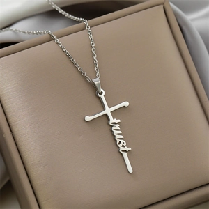 Detailed view of silver stainless steel cross necklace with script 'trust' pendant design