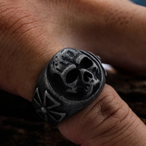 Gothic skull ring for men with cross patterns in vintage silver finish on wood background