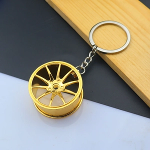 Close-up of golden multi-spoke wheel hub keychain with polished metal ring finish